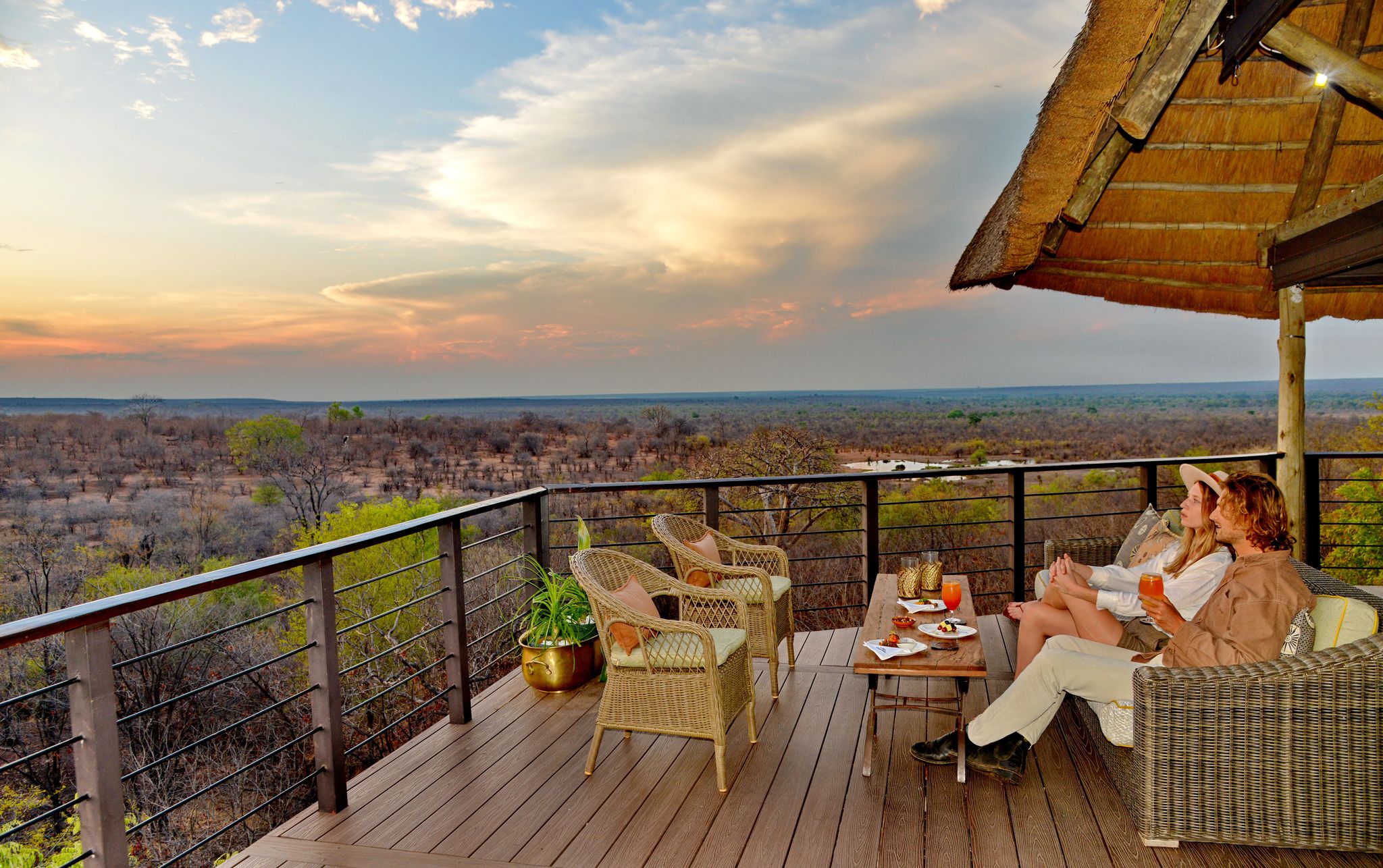 Guests at sunset on a private deck overlooking the Zimbabwean bushveld